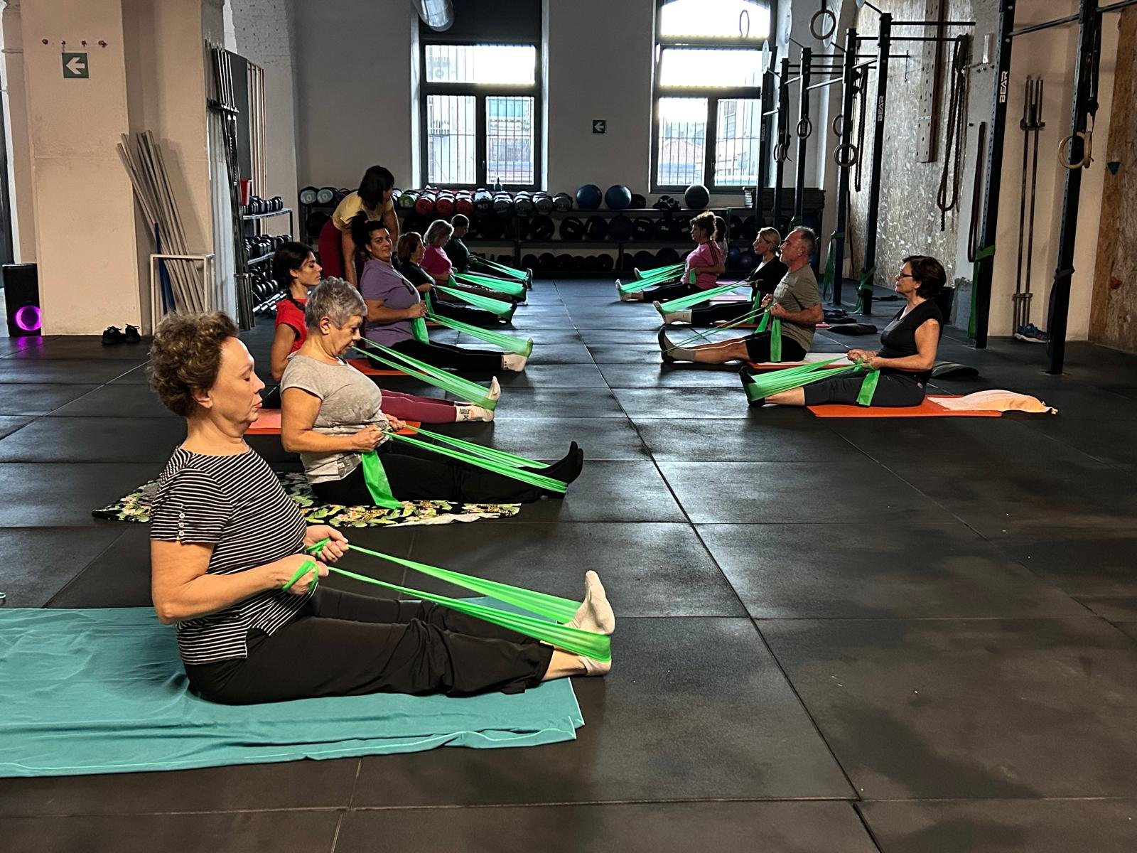 Classe di Pilates con gli elastici sui tappetini del box